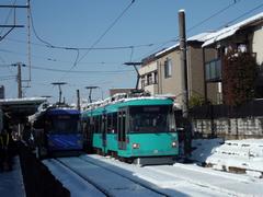 雪の上を走る世田谷線の写真