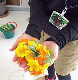 公園サポーターのレクチャーにより、公園の草花を使った花飾りを作ります