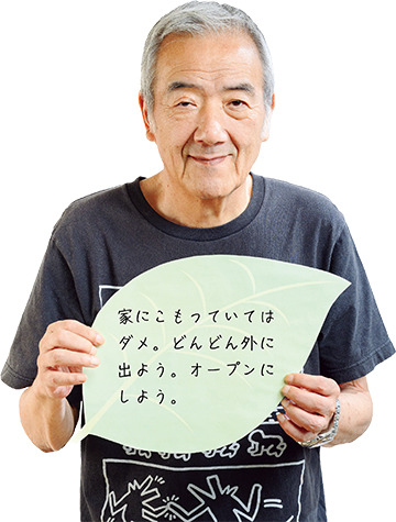 「家にこもっていてはダメ。どんどん外に出よう。オープンにしよう。」と書かれたリーフを手に持つ貫田直義さんの写真