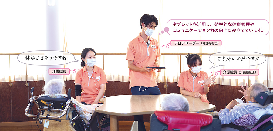 介護職員「体調よさそうですね」、フロアリーダー（介護福祉士）「タブレットを活用し、効率的な健康管理やコミュニケーション力の向上に役立てています。」、介護職員（介護福祉士）「ご気分いかがですか」